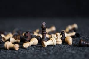 Scattered chess pieces on a blurred black background.